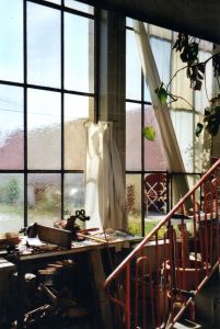 Blick auf die  5 Meter hohe und mind. 20 Meter lange Fensterfront in der oberen Werkstatt. Dahinter ist der Innenhof.